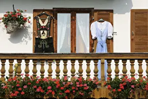 Farmhouse with lederhosen and a dirndl hanging on the shutters