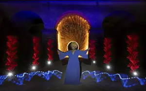 Fascinating light show with a woman in front of a symbolic backdrop under an arch