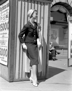 Fashionable in the 1950s. A young woman wears a typical 1950s two piece dress with matching skirt and jacket