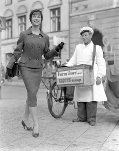 Fashionable in the 1950s. A young woman wears a typical 1950s two piece dress with matching skirt and jacket