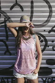 A fashionable woman poses against an urban backdrop