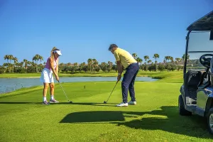 Father and daughter duo playing golf on a sunny day