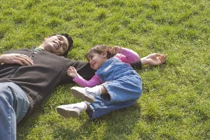 Father and daughter playing and enjoying on green grass at Botanical Garden