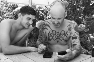Father and son in garden on mobile phone