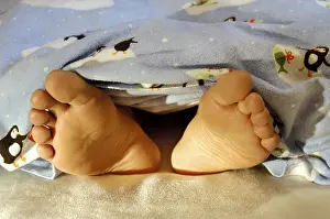 Feet are looking out the blanket