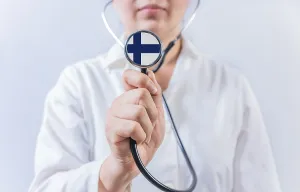 Female doctor holding stethoscope with Finland flag