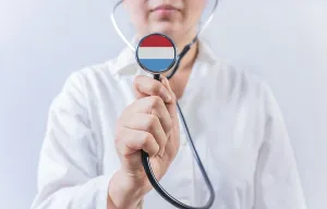 Female doctor holding stethoscope with Luxembourg flag