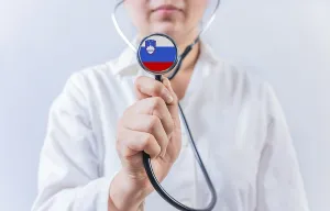 Female doctor holding stethoscope with Slovenia flag