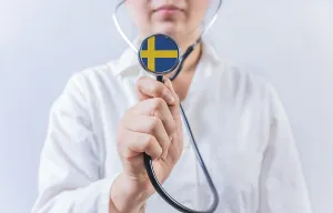 Female doctor holding stethoscope with Swedish flag