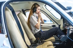 Female pilot sitting in the cockpit of a small aircraft