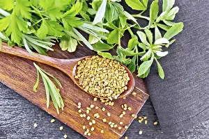 Fenugreek seeds in a spoon on a brown plate with spicy herbs