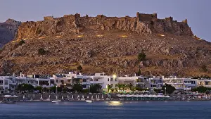 Feraklos fortress, Old castle at dusk with illuminated town and calm sea below