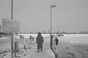 Ferry dock, people walk across ice rink