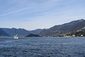 Ferry sails on Lake Como with mountains in the background