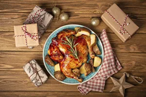 Festive Christmas dinner with roasted whole chicken top view on wooden rustic background with Xmas toys