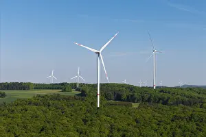 Field with several wind turbines under a bright blue sky