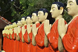 Figures of Buddhist monks in front of a monastery
