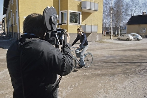 Filming in the 1970s. Actor singer Bjoern Skifs is seen riding a bicycle when passing the cinematographer with his film camera on his shoulder