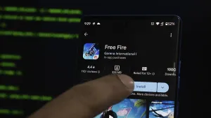 Finger pointing at Free Fire app store page on a smartphone with a dark background