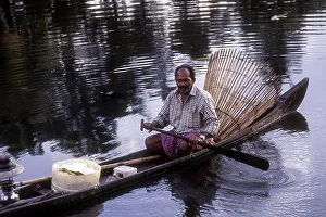 Fisherman with bamboo fishing basket fishing in the backwater of Kuttanad