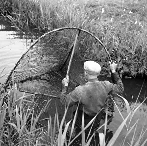 Fisherman with net in the river, ca