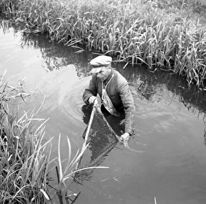 Fisherman with net in the river, ca