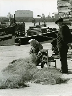 Fishermen mending nets, harbour