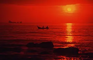 Fishing boat at sunset, silhouettes