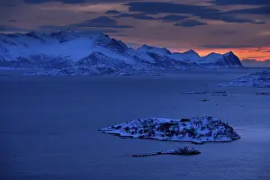 Fjord with mountains in winter at sunset