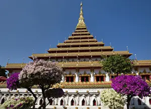 Flowering bushes in front of nine-story stupa Phra Mahathat Kaen Kakhon