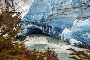 Flowing water under an impressive blue glacier wall