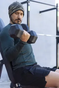 Focused athlete lifts dumbbells