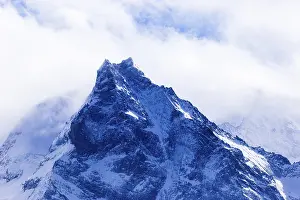 Fog envelops the snowy summit of the mountain Le Besso