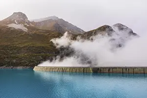Fog rises over the dam of the Lac de Moiry Reservoir