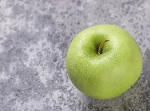 Food, Juicy ripe green Apple with water drops on a concrete background