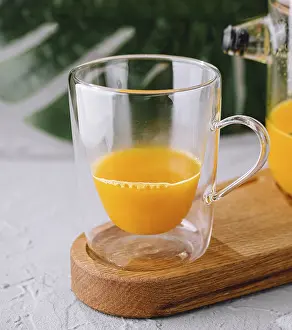 Food, Orange smoothie served in a clear glass beside a full pitcher