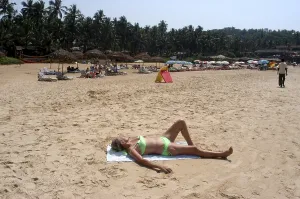 A foreign tourist enjoying sun bath on the Sinquerim beach of Goa