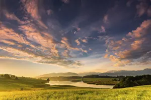 Forggensee with mountain meadow and the Allgaeuer mountains in the background at sunrise