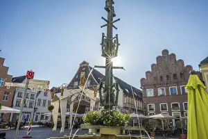 A fountain with fountains in a central square surrounded by half-timbered houses