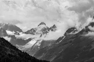 Four-thousand metre mountains and glaciers in clouds
