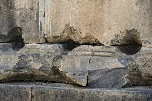 Fragment of a stone wall of an ancient temple made of tufa