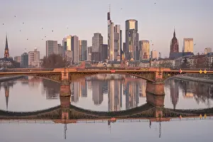 The Frankfurt bank skyline is reflected in the Main River in the morning