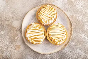 French lemon tart with meringue on brown concrete background