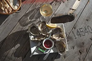 Fresh oysters with lemon and wine served on a rough wooden table