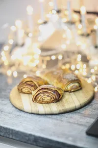 Fresh pastries on a board surrounded by candles and fairy lights