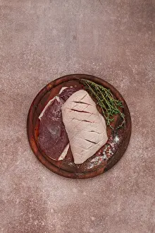 Fresh raw duck breasts, on a wooden chopping board