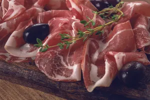 Freshly cut dried meat, served with olives and herbs