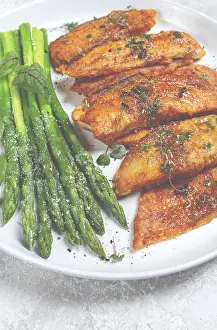 Fried fish fillet, tilapia with asparagus