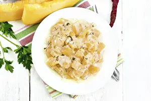 Fried pumpkin with garlic, spices and herbs in sour cream sauce in a plate on a towel