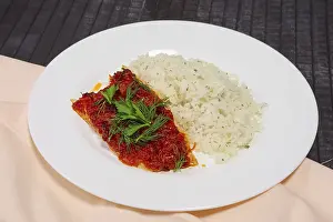 Fried with spices white sea fish served with rice and dill